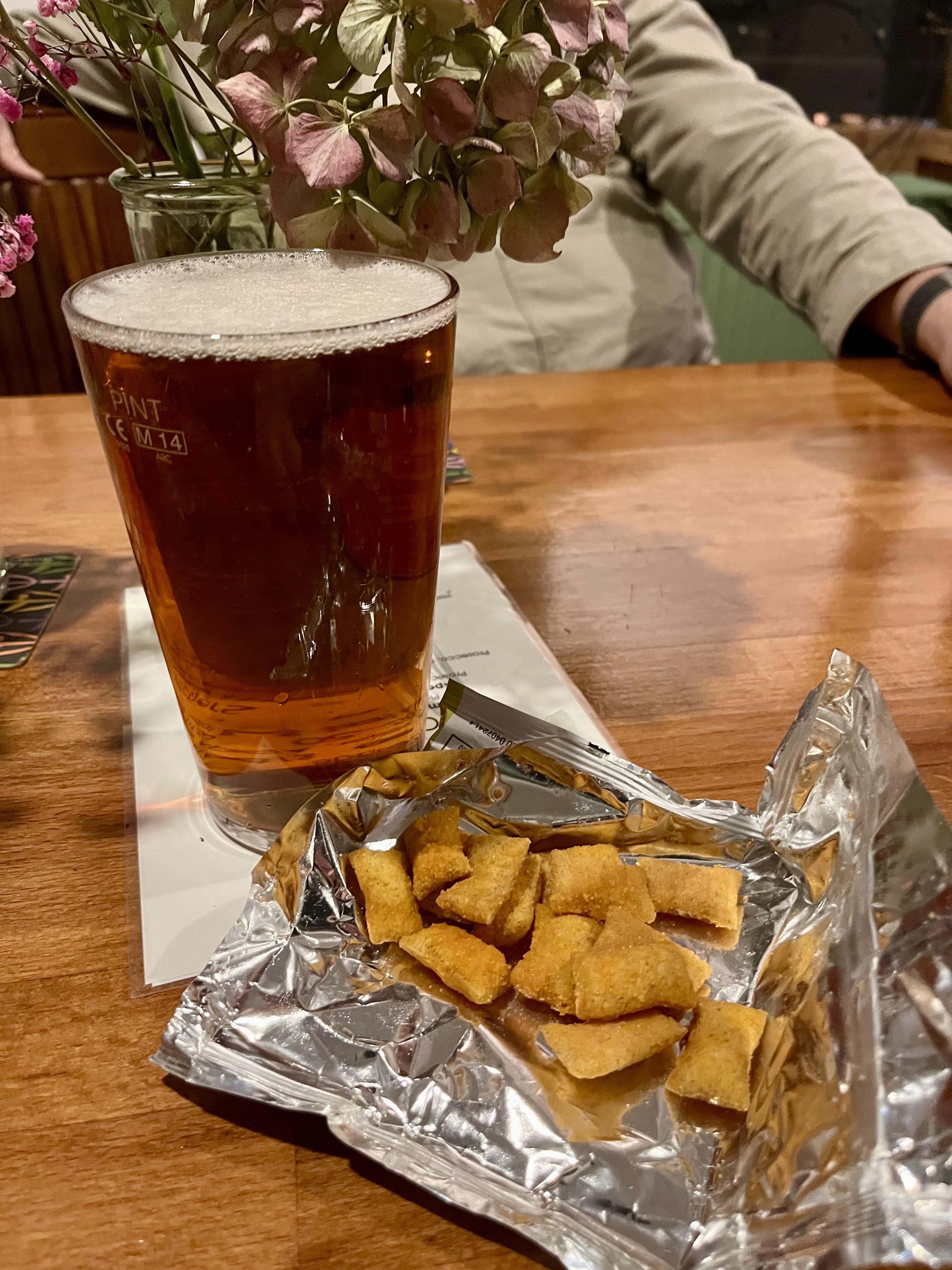 A pint of beer and bowl of scampi fries